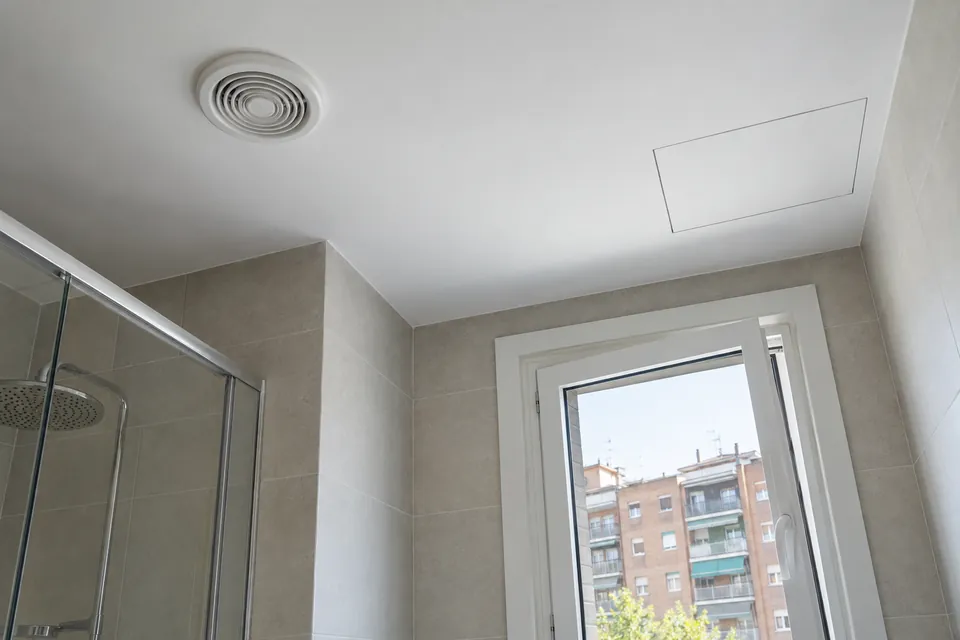 Sostre de bany reformat amb reixeta de ventilació i registre al fals sostre