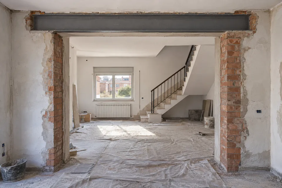 Pas obert en un mur de càrrega amb una biga metàl·lica nova durant la reforma d'una casa